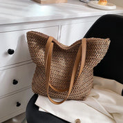 Woven straw tote bag beige on lap with person