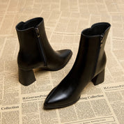 Black leather ankle boots angled view with zipper and heel detail