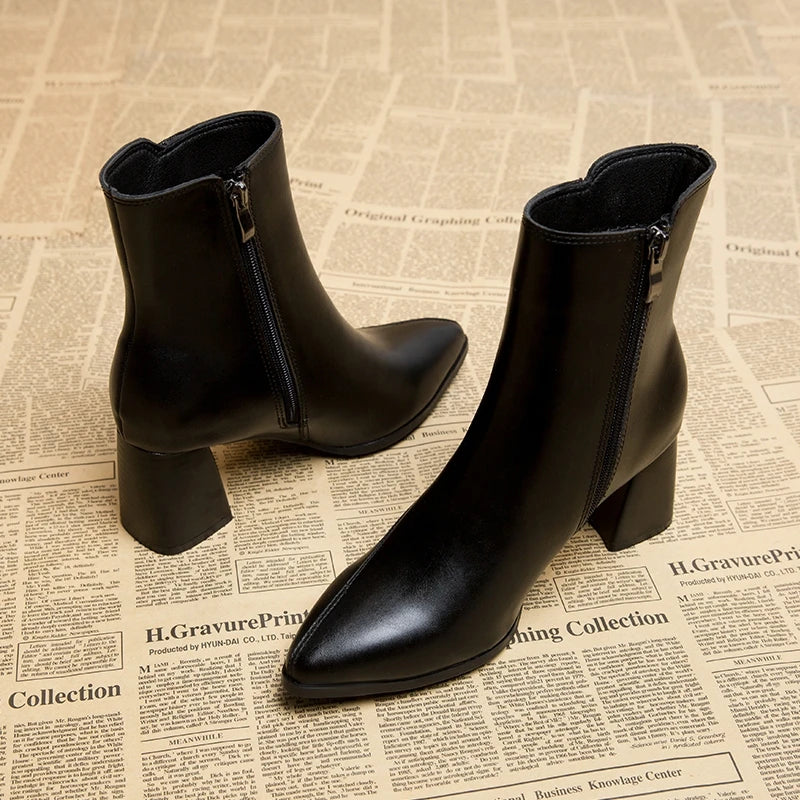 Black leather ankle boots angled view with zipper and heel detail
