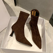 Brown suede ankle boots in box, angled view