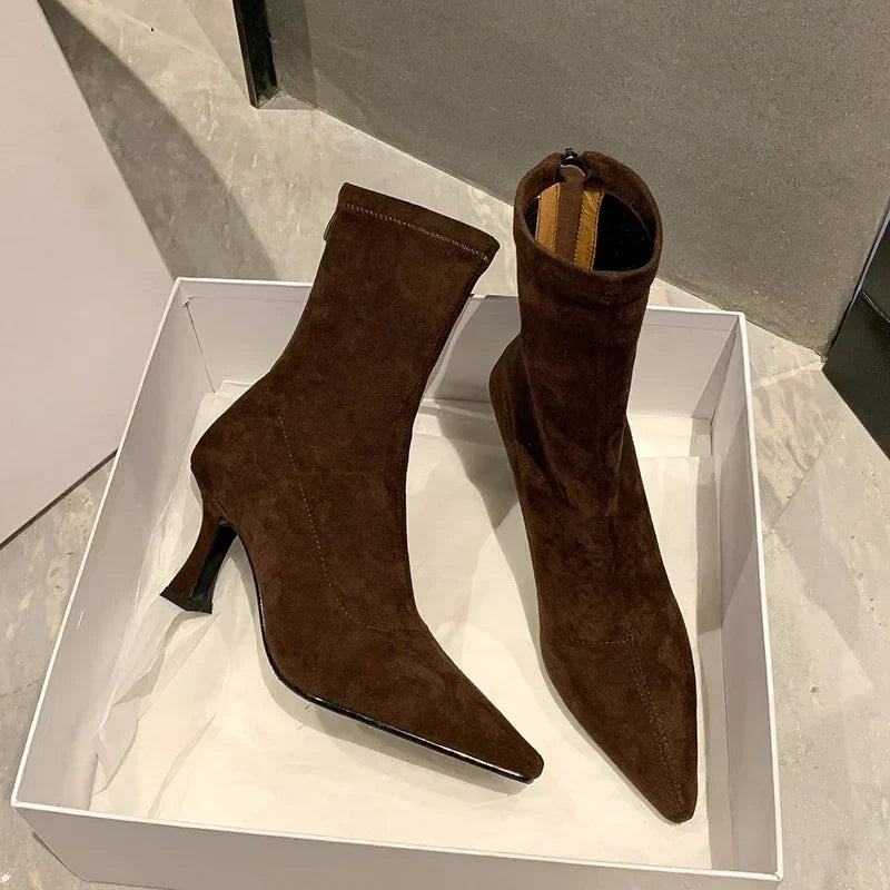 Brown suede ankle boots in box, angled view