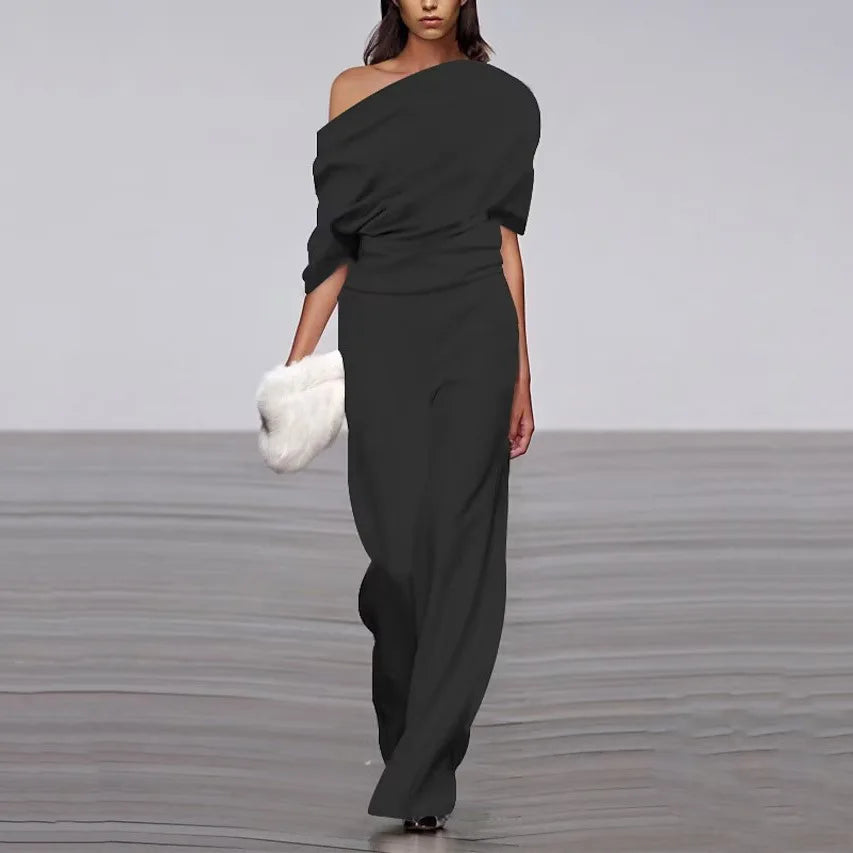 Black jumpsuit with asymmetrical shoulder and wide legs, studio front view