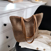 Woven straw tote bag beige on lap with person wearing white jacket