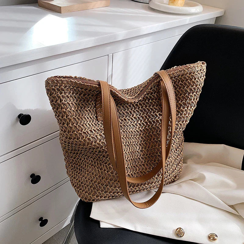 Woven straw tote bag beige on lap with person wearing white jacket
