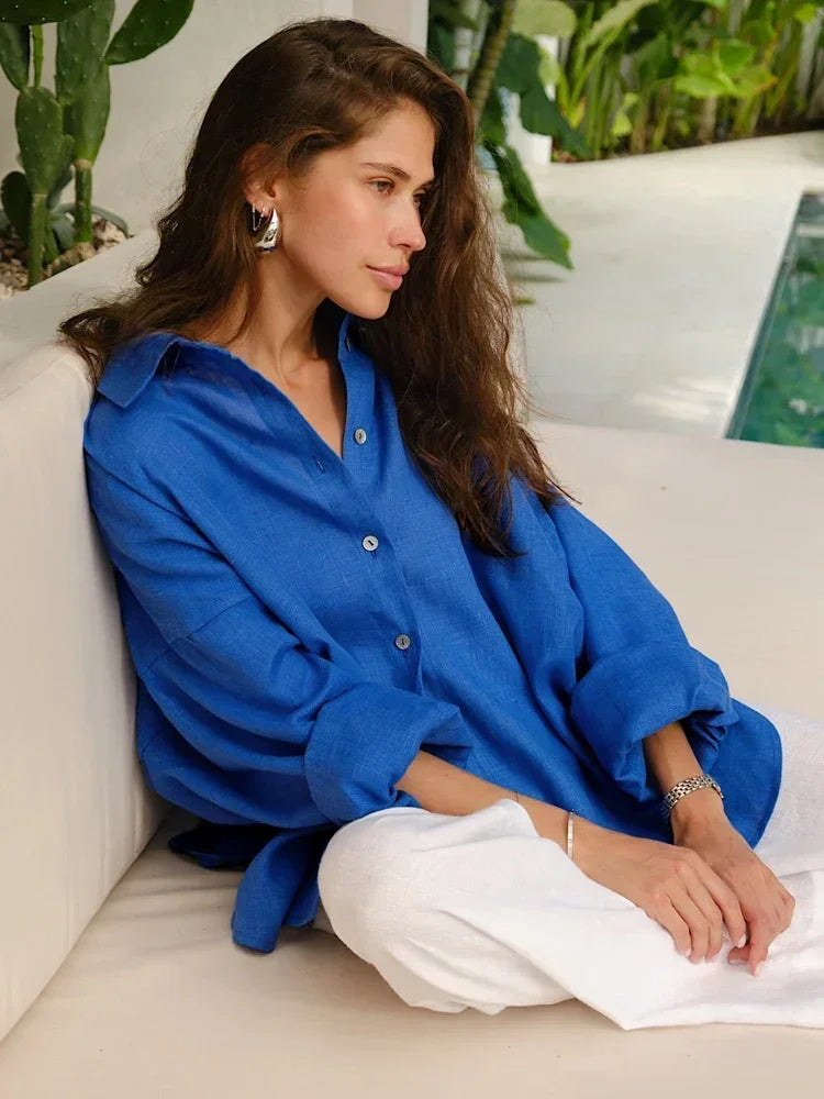 Blue linen blouse with white pants, relaxed pose