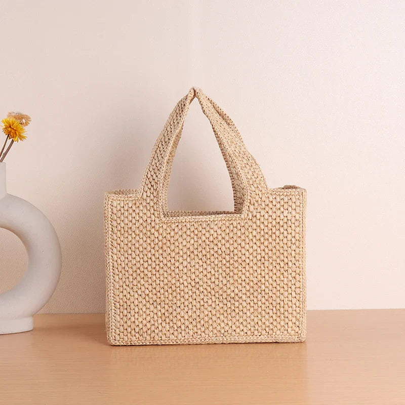 Woven straw tote bag beige front view with vase
