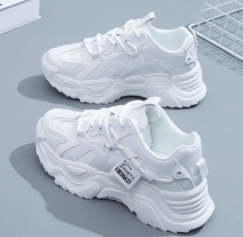 Witte sneakers met textuurpatroon en dikke zool detail shot