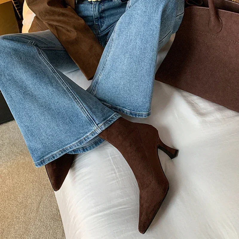 Brown suede ankle boots worn with jeans, front view