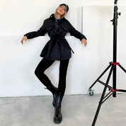 Dames gewatteerde jas zwart met knoopsluiting en zakken, model pose