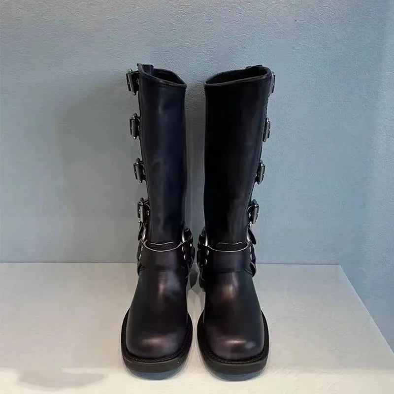 Black leather biker boots with buckles, front view on display