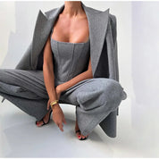 Gray herringbone jumpsuit with blazer and wide pants crouching pose