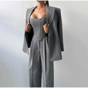 Gray herringbone suit with blazer and wide pants front view, hands adjusting blazer