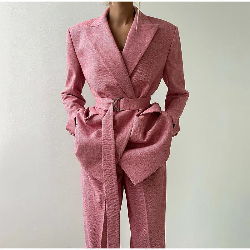 Pink herringbone suit with blazer and wide pants front view, hands adjusting blazer