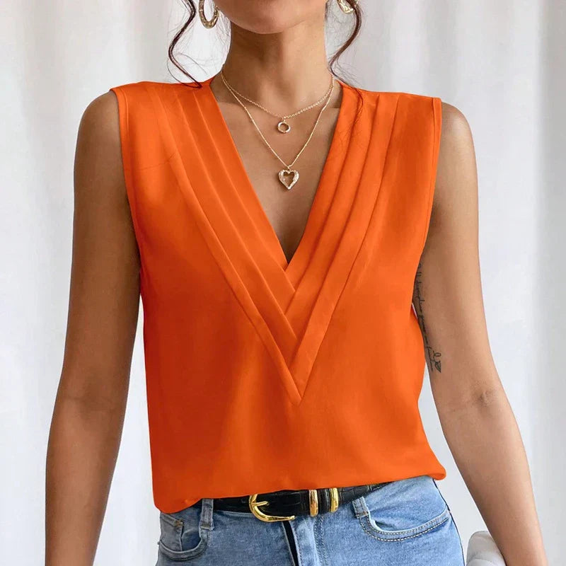 Orange blouse with V-neck and pleats, close-up detail
