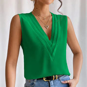 Green blouse with V-neck and pleats, close-up detail