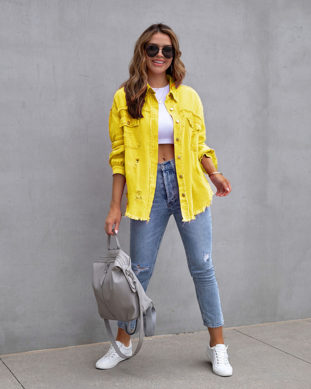 Gele verscheurd denim jas met cropped top en jeans lifestyle shot