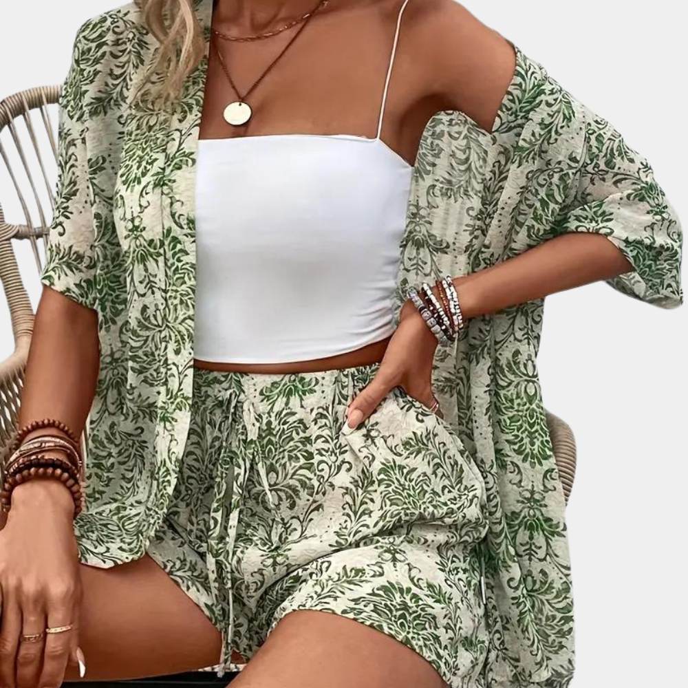 Two-piece set with green floral print and white crop top, seated side view.