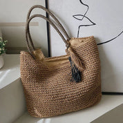 Woven straw tote bag with tassel detail, front view