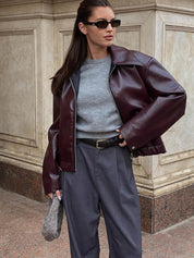 Oversized faux leather jacket maroon worn with trousers