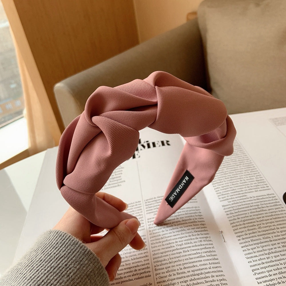 Haarband roze stof met knoopdetail bovenaanzicht