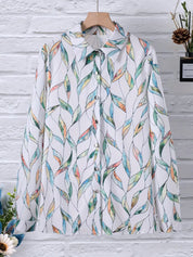 Blouse with leaf print and white background, front view on mannequin with flowers