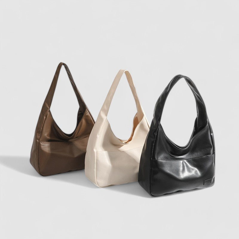 Black, beige, and tan leather slouchy shoulder bags side by side