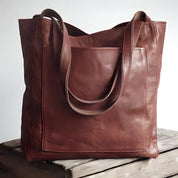 Leather tote bag with large front pocket, dark red color, front view