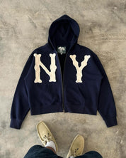 Unisex vest met 'NY' logo in beige op donkerblauwe stof, front view