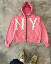Pink zip-up hoodie met witte 'NY' borduurwerk, front view
