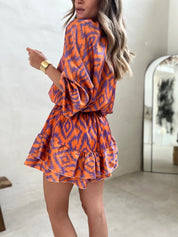 Orange and purple patterned summer dress side view showing ruffle hem