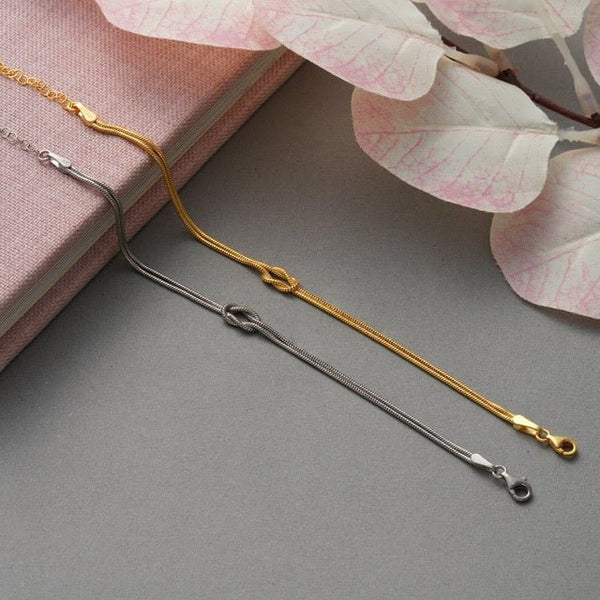 Armband met minimalistische liefdesknoop in goud en zilver, detailopname