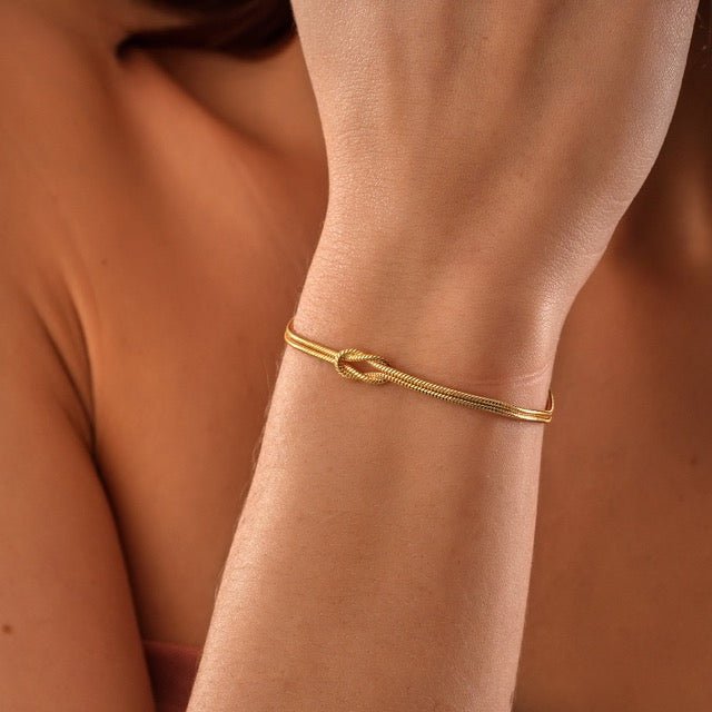 Armband goud minimalistisch liefdesknoop detail shot