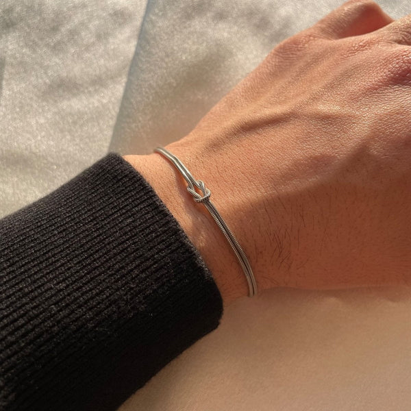 Armband met minimalistische liefdesknoop zilveren slangenpatroon draagweergave