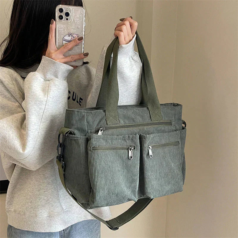 Green corduroy shoulder bag with multiple pockets, front view