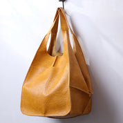 Yellow slouchy tote with large exterior pockets, hanging view