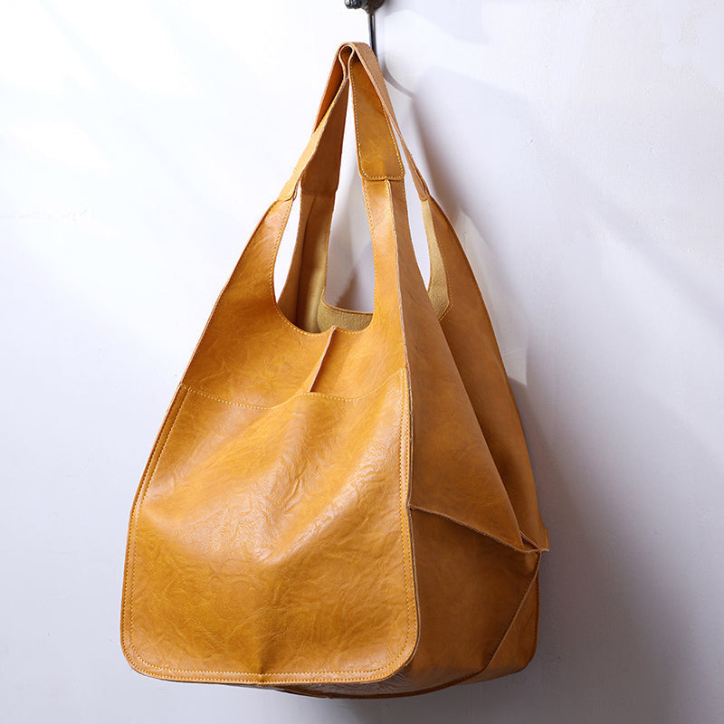 Yellow slouchy tote with large exterior pockets, hanging view