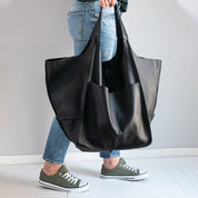 Black slouchy tote with large exterior pockets, front view