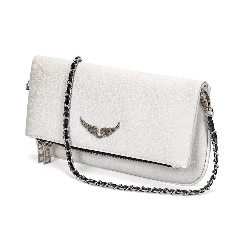 White leather clutch with silver chain and wing embellishment, angled view